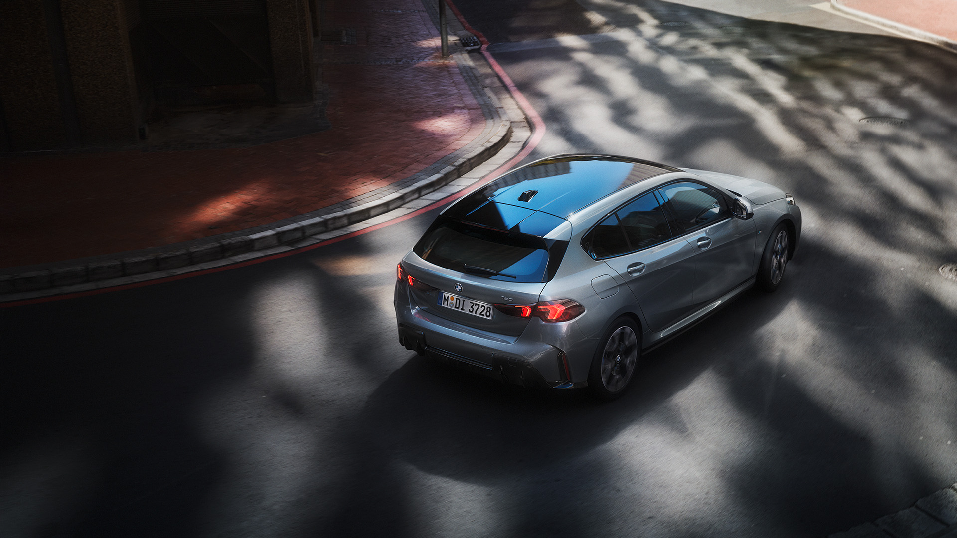 Die Heckansicht des BMW 1er (2024) überzeugt mit sportlichem, modernem Design. Die markanten LED-Rückleuchten verlaufen horizontal und betonen die Breite des Fahrzeugs. Die Heckpartie ist klar strukturiert, mit einem schmalen Spoiler am Kofferraumdeckel und einem sportlichen Diffusor im unteren Bereich. Die Abgasendrohre sind je nach Ausstattung sichtbar oder verdeckt. Die Linienführung ist dynamisch und unterstreicht den agilen Charakter des Fahrzeugs. Die hochwertige Lackierung und die präzise Verarbeitung sorgen für eine exklusive Optik.