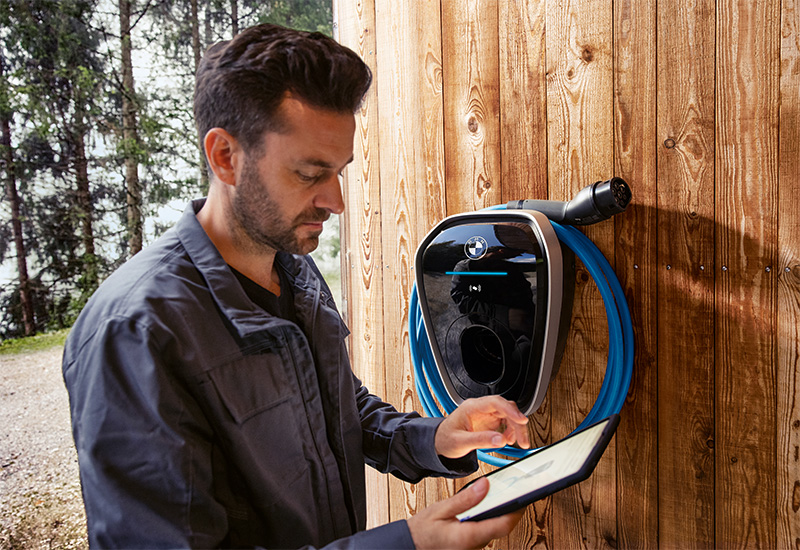 Eine Bedarfsanalyse für Elektromobilität: Ein Fachmann prüft die Voraussetzungen für die Installation einer Wallbox. Im Bild sind eine Wandladestation (Wallbox) und ein Tablet zu sehen.