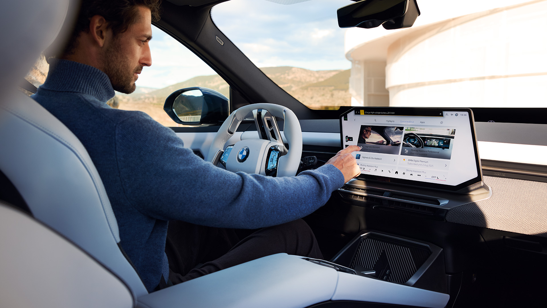 BMW iX3, Fahrer nimmt Einstellungen auf dem Display vor