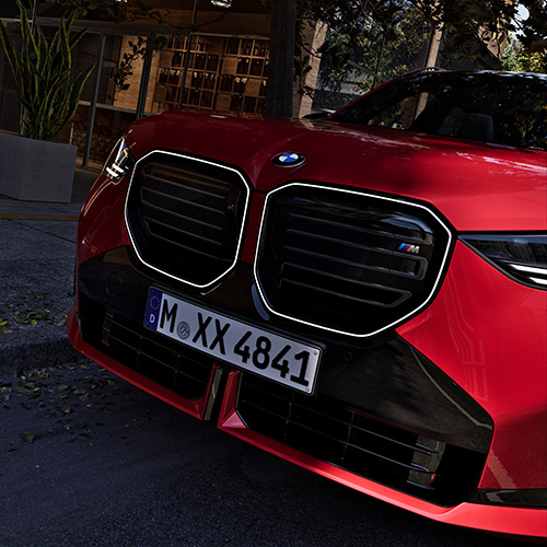 BMW X3 M50 xDrive in rot. Detailaufnahme der Front mit der Beleuchteten Niere und dem BMW M Emblem