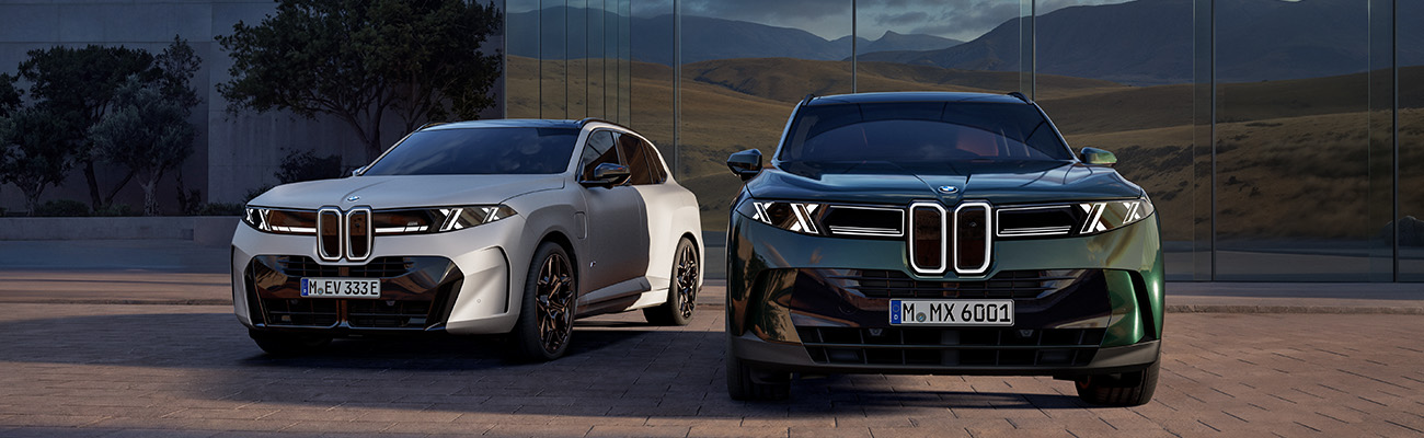BMW X5 G65, zwei Fahrzeuge vor modernem Gebäude mit Glasfassade